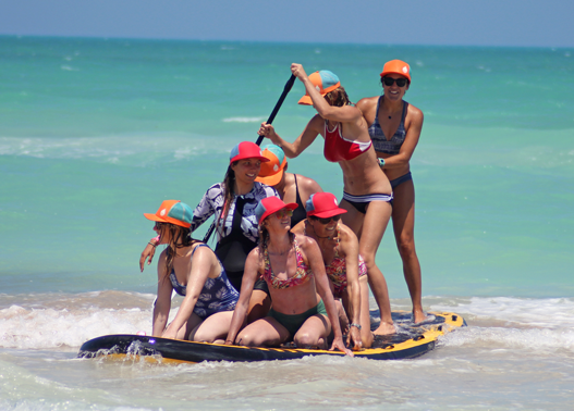 Girls SUPing with Sensi Bikinis and Buoy Wear's floating hat